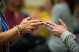 two yogis touching finger tips together
