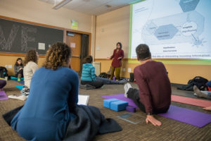Yoga teacher, Sarahjoy Marsh, showing a power point presentation about trauma informed yoga.